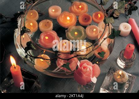 Bougies flottantes dans un bol en verre sur une table Banque D'Images