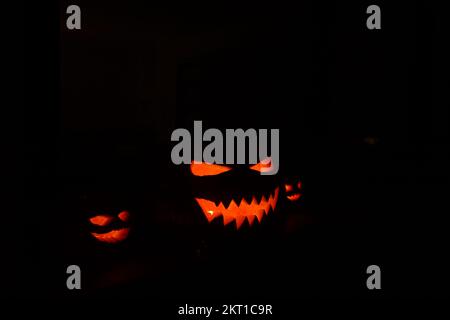 Citrouilles d'halloween sculptées dans l'obscurité Banque D'Images