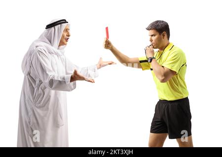 Portrait d'un arbitre de football qui a tiré un coup de sifflet et montrant une carte rouge à un homme arabe en colère isolé sur fond blanc Banque D'Images