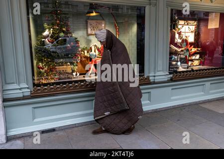 Homelessman devant Fortnum & Mason à Londres aux fenêtres de Noël du Fortnum pendant la période de fête qui a précédé Noël 2022. Banque D'Images