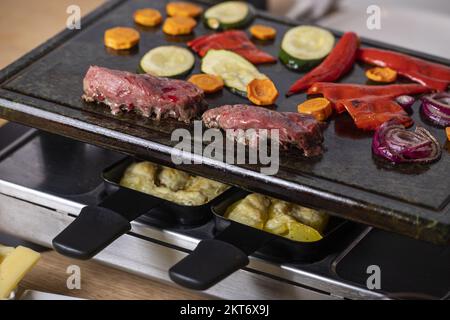 Raclette suisse avec viande et légumes Banque D'Images