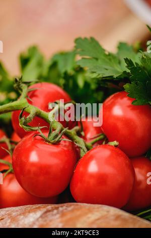 Tomates rouges mûres bio fraîches avec pain blanc, persil et feuilles de basilic dans une boîte en bois dans un marché de la rue, gros plan, vertical Banque D'Images
