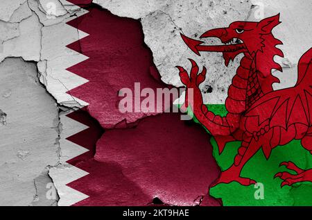 Drapeaux du Qatar et du pays de Galles peints sur un mur fissuré Banque D'Images