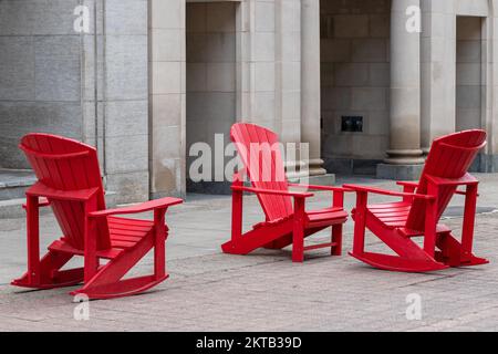 Chaises extérieures rouges près du bâtiment dans la rue Sparks, au centre-ville d'Ottawa, Canada. Banque D'Images