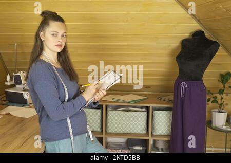 Affaires de mode. Le créateur de mode dessine un croquis des futurs vêtements. Banque D'Images