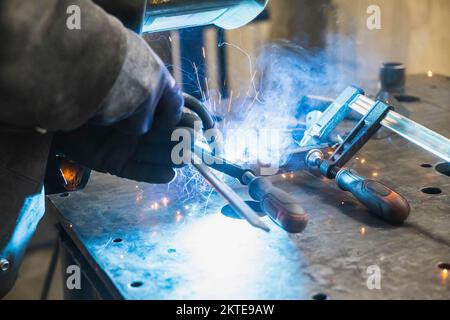 Soudage semi-automatique avec étincelles et fumée en usine Banque D'Images