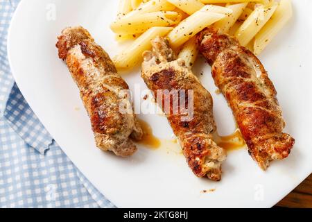 Côtelette de porc cuite avec des pâtes de penne. Recette de cuisine italienne. Banque D'Images