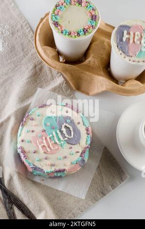 mini-gâteau à bento fait maison avec un joli décor coloré et des lettres « bonjour », nouvelle tendance de confiserie. Les gobelets en papier avec cakey sont dans une boîte, à la mode des Banque D'Images