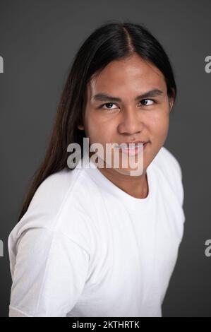 Photo d'un portrait d'un homme indien en gros plan isolé sur fond gris d'un studio Banque D'Images