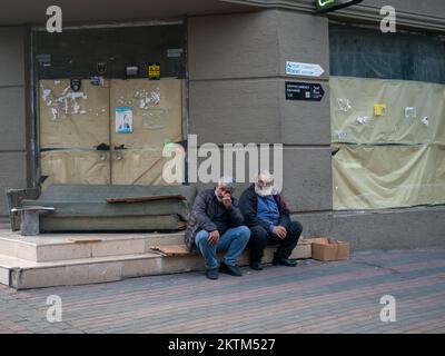 Batumi, Géorgie. 11.21.2022 deux hommes sont assis contre un mur à l'extérieur. Ancien quartier. Abandonné. Banque D'Images