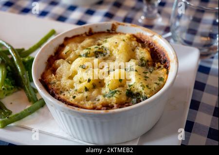 Tarte aux lentilles et aux champignons assaisonnée cuite lentement dans du vin rouge, recouverte de purée de cheddar et servie avec des légumes de saison de gros plan Banque D'Images