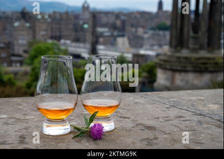 Deux verres de whisky single malt scotch et vue de Calton Hill au parc et dans les vieux quartiers d'Edimbourg le jour pluvieux d'été, Écosse, Royaume-Uni Banque D'Images