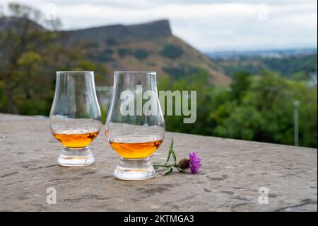 Deux verres de whisky single malt scotch et vue de Calton Hill au parc et dans les vieux quartiers d'Edimbourg le jour pluvieux d'été, Écosse, Royaume-Uni Banque D'Images