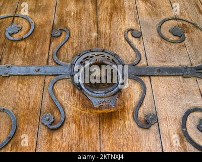 Porte antique en fer forgé noir tirer sur la vieille porte en bois de la planche de fermeture. Banque D'Images