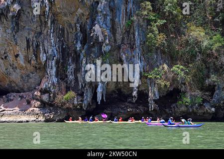 Les touristes explorent les falaises de calcaire érodées en canoë dans la baie de Phang Nga, en Thaïlande, en Asie Banque D'Images