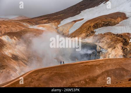 Randonneurs sur une montagne rhyolite colorée, sources d'eau chaude à l'arrière, zone géothermique de Hveradalir, Kerlingarfjöll, Highlands islandais, Islande, E Banque D'Images