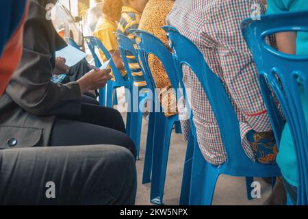 Main de la femme âgée tient un stylo pour se préparer à prendre des notes de la réunion de la communauté locale. Groupe prenant des notes lors de la réunion de quartier. Remarque t Banque D'Images
