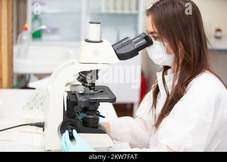 Bélarus, Gomil, 31 mai 2021. City Central Hospital.A biologiste regarde à travers un microscope. Femme biologiste. Un assistant de laboratoire avec un microscope Banque D'Images