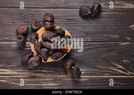 Figues séchées sur scène en bois et sur fond en bois. Pose à plat Banque D'Images