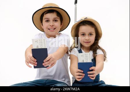 Bon voyage ! Famille de voyageurs frère et sœur avec valise, billets d'avion et passeports sur fond blanc Banque D'Images