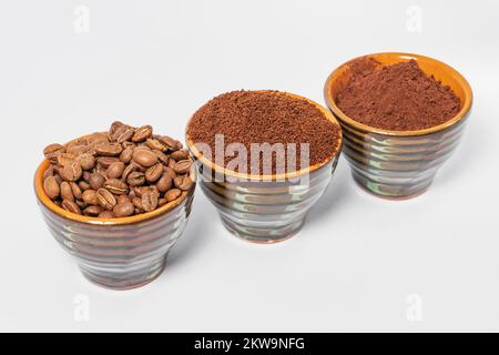 trois petits soucoupes avec grains de café, café moulu et cacao sur fond blanc, place pour le texte et l'espace de copie. Banque D'Images