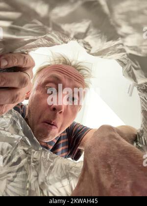 Homme séparant les déchets à la maison, jetez la litière dans le bac Banque D'Images