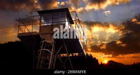 Tour de guet structure métallique, coucher de soleil coloré avec horizon noir en arrière-plan Banque D'Images