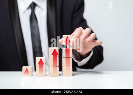 Blocs en bois avec des flèches rouges icônes, main tenant cube, business profit Success concept Banque D'Images