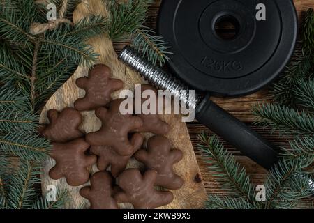 Biscuits de Noël en pain d'épice, assiette de poids à haltères, branches d'arbre. Fitness saison des fêtes composition du régime d'hiver. Concept d'entraînement de gym. Banque D'Images