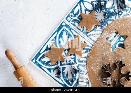 Faire des biscuits de Noël faits maison, rouler la pâte, couper les biscuits avec des moules. Banque D'Images