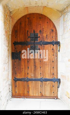 Ancienne porte en bois avec arche ronde et décorations en métal. Ancienne porte du château du Moyen-âge. Banque D'Images