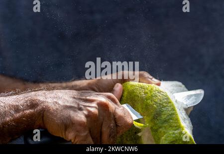 Un homme qui s'éverdit de l'ombre, des grands-agrumes pendant que le spray se déplace Banque D'Images