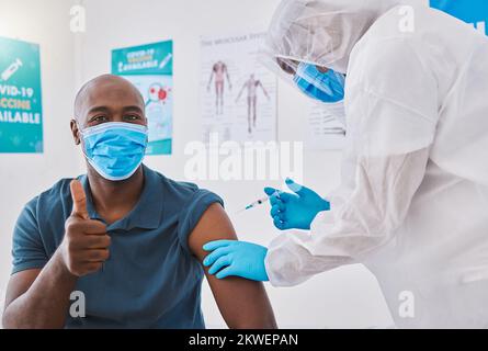 Pouces vers le haut, vaccin et injection de covid sur un bras de homme avec lui portant un masque pour rester en sécurité. Médecins aiguille injectant un homme en bonne santé se protégeant contre Banque D'Images