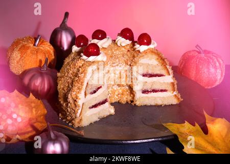 Gâteau allemand Frankfurter Kranz ou Frankfurt Crown Cake. Bisquit à la crème au beurre et aux cerises. Coupez la moitié du gâteau. Décoration automnale. Banque D'Images