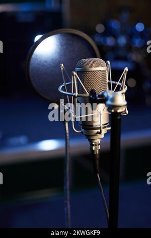 Microphone avec écran de protection pour les pop-up à l'arrière-plan d'un studio d'enregistrement professionnel. Support de microphone avec condensateur pour des enregistrements vocaux Banque D'Images