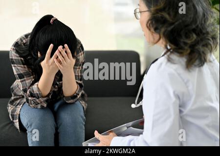 Jeune femme asiatique stressée et dépressive ayant un rendez-vous avec son psychiatre personnel ou psychologue à la clinique. Problème de santé mentale conce Banque D'Images