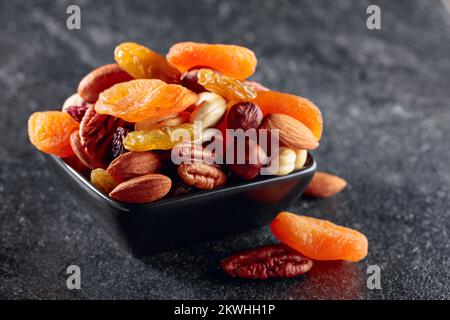 Fruits secs et noix assorties sur une table en pierre noire. Banque D'Images