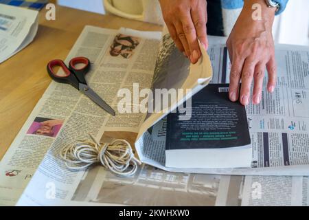 Emballage-cadeau durable, dans les journaux, sans ruban adhésif, juste attaché avec le cordon, Banque D'Images