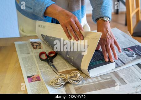 Emballage-cadeau durable, dans les journaux, sans ruban adhésif, juste attaché avec le cordon, Banque D'Images