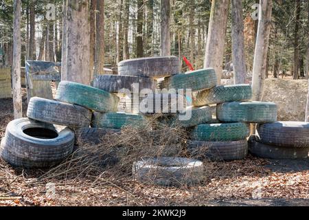 Murs de pneus dans les bois, aréna de paintball Banque D'Images