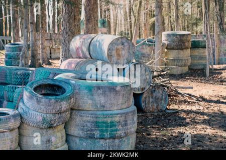 Murs de pneus dans les bois, aréna de paintball Banque D'Images