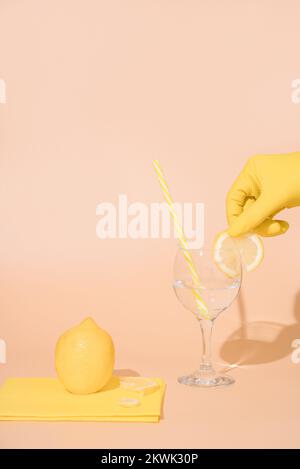 Le barman en gants prépare un verre d'eau et une tranche de citron. idée de concept Banque D'Images