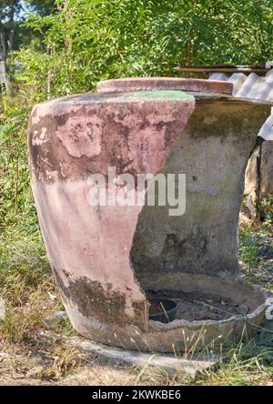 Un grand pot d'eau traditionnel endommagé sur la ferme na en Thaïlande rurale. Banque D'Images