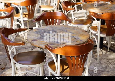 Street café en été avec des chaises et des tables en bois vintage sur une rue touristique. Restaurant ou café vide sans visiteurs. Photo de haute qualité Banque D'Images