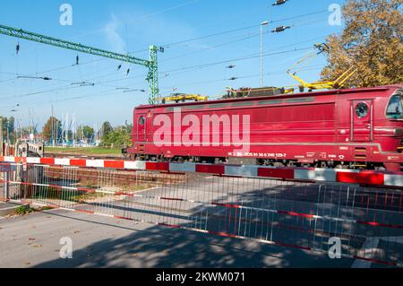 Le train de fret s'accélère dans un crapaud rural. Après que la barrière de circulation a été abaissée photographiée au lac Balaton, en Hongrie Banque D'Images