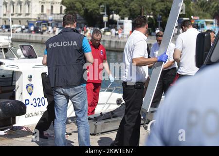 Split, Croatie - corps de malheureux Irishman trouvé en mer. Le cadavre sera transporté au service de pathologie de la Firule de Split KBC où l'autopsie déterminera la cause du décès. Irishman a disparu début mardi, suivi immédiatement de recherches intensives. Ce jour-là, le jeune homme (qui était apparemment au Festival Ultra Europe) a grimpé le mât du bateau ancré Sagena, d'où il s'est plongé dans la mer et s'est probablement noyé. Ses amis regardaient l'extraction du corps et se mirent. Banque D'Images