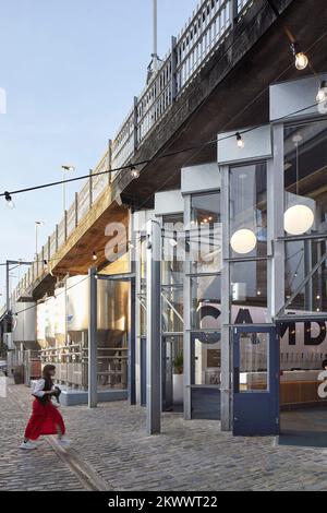 Vue le long de la façade avec les réservoirs à bière. Camden Town Beer Hall, Londres, Royaume-Uni. Architecte : Gundry & Ducker, 2021. Banque D'Images