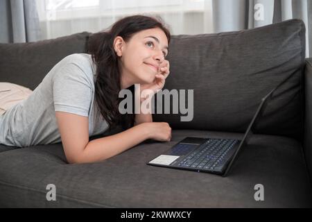 Jeune fille de chat avec des amis en ligne sur ordinateur portable Banque D'Images