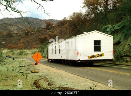 Feux de forêt, vallée de Pauma, Californie, 28 novembre 2007 Une maison mobile est remorquée à destination par la réserve indienne de Rincon et dans la réserve indienne de la Jolla, dans le sud de la Californie. Les maisons mobiles sont utilisées comme option de logement à la suite des feux sauvages dévastateurs qui ont balayé la région. Le vert sur le terrain est ce qui reste de produit ignifuge utilisé lorsque les pompiers ont combattu les incendies à propagation rapide le mois dernier. Amanda Bicknell/FEMA... Photographies relatives aux programmes, aux activités et aux fonctionnaires de gestion des catastrophes et des situations d'urgence Banque D'Images