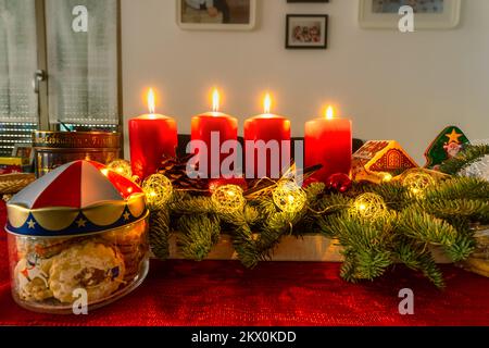 Quatre bougies allumées sur une couronne d'advents à l'heure de noël. Banque D'Images